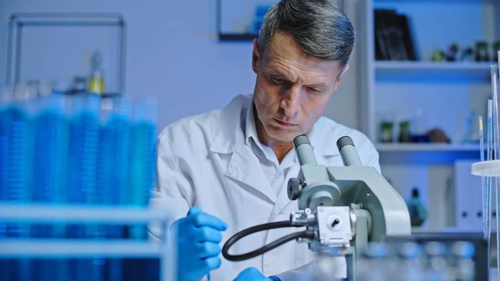 Doctor with microscope and pipettes